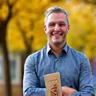 Photo de Julien Leclerc souriant tenant une boulangerie Blé Sauvage